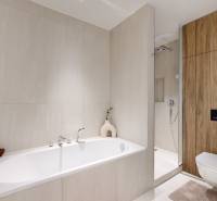 A stylish bathroom in a 3-room apartment with a bathtub, shower, and wooden paneling.