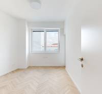 A bright room with a parquet floor and a window in a 3-room apartment.