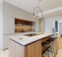 Kitchen and living room in a 3-room apartment with an island and wooden flooring.