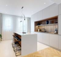 A kitchen in a 3-room apartment with an island, light cabinets, and wooden elements.