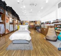 Bedding and pillows displayed in a retail space with wooden flooring.