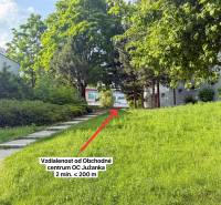 Greenery and sidewalk near the shopping center on Kyjevská Street in Trenčín.