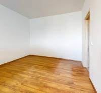Empty room with wooden flooring in a studio apartment. White walls, simple design.