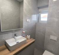 Bathroom in a 4-room apartment with a sink, cabinet, mirror, and toilet.