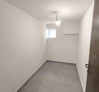 A small room with white walls and a gray floor in a 4-room apartment.
