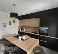 The kitchen in a 4-room apartment with dark cabinets and wooden details.