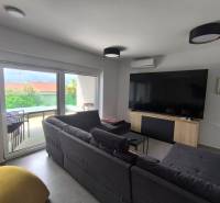 Living room in a 4-room apartment with a sofa, TV, and a view of the terrace.