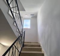 A staircase in a 4-room apartment with a window and elegant railings.