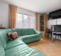 The interior of a family house with a corner sofa and a television on the wall.