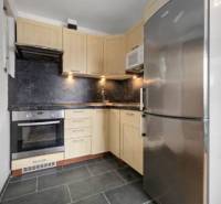 A kitchen in a family house with wooden cabinets and a stainless steel refrigerator.