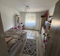 Children's room with a bed and a window in a 3-room apartment, light wooden floor.