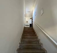 A staircase with white walls leading to an apartment in a 3-room flat.