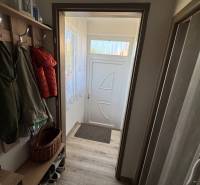 Hallway of a 3-room apartment with coat racks, a shoe cabinet, and doors with a transom window.