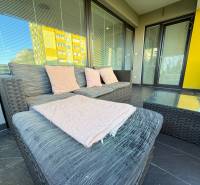 Terrace of a 4-room apartment in Topoľčany with seating, a glass table, and a sofa.
