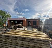 Construction of a family house in Opoj in the initial phase, with prepared building materials.