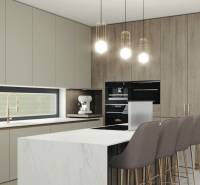 A kitchen in a family house with a white marble island and stylish lighting fixtures.