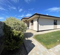 A family house in Prešov with a lawn, paving, and a structure next to the wall.