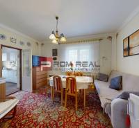 Living room in a family house with a sofa, dining table, and wall decorations.