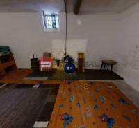 Basement of a family house with a small window, carpet, and interior furnishings including an armchair.