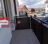 The balcony of a 2-room apartment on Slavomírova Street, overlooking the surrounding buildings and cars.