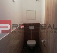 A simple toilet with tiled walls, part of a 2-room apartment on Slavomírova Street.