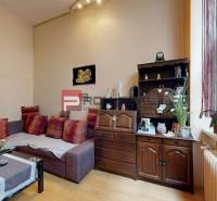 Living room in a two-room apartment with a fabric sofa and wooden furniture.