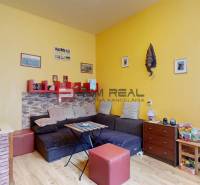 Living room of a two-room apartment with colorful walls, a comfortable sofa, and decorations.