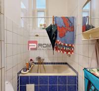 Bathroom with a bathtub and a mirrored cabinet in a 2-room apartment, white tiles, blue tiles.