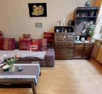 A living room with a sofa set, a wooden cabinet, and houseplants in a two-room apartment.