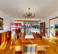 Dining room in a family house with a large wooden table and paintings on the walls.