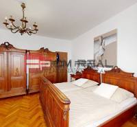 A bedroom in a family house with wooden furniture and parquet flooring.
