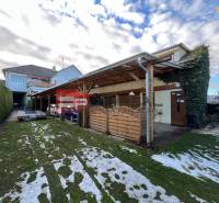 Family house in Trnava, garden, shelter, and garage door with closed doors.