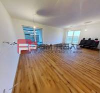 A family house with laminate flooring and large windows, simply furnished.