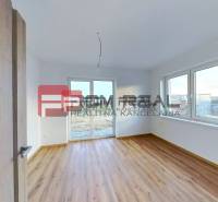 A room in a family house with a wooden floor and large windows.