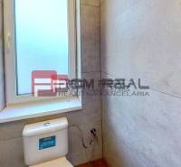 Bathroom in a family house with a window and a toilet.