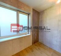A family house bathroom with a shower, light tiles, and a wooden floor.