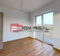 A room in a family house with laminate flooring and patio doors.