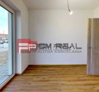 A room in a family house with a wooden floor and spacious doors to the terrace.