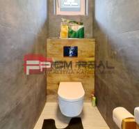 Bathroom in a family house with a toilet, sink, and storage space.