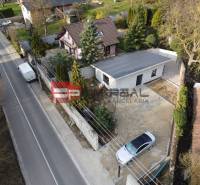 A family house in Pezinok with a garden and a driveway, with a car in the yard.