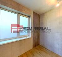 The interior of a family house with a window in a paneled room, light coming from above.