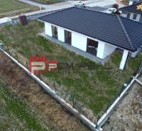 A family house in Častá with a sloped roof, surrounded by a fence, grassy plot.