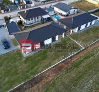 Family house in Častá with multiple buildings, garden, paved parking area, fencing.