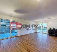 A bright living room with wooden flooring and large windows in a family house.