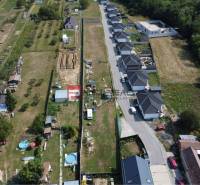 Aerial view of residential plots in Štefanová, adjacent to a row of houses.