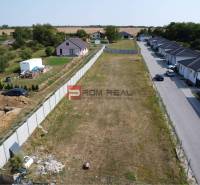 Plots - housing in Štefanová, next to an empty parcel, surrounded by rural houses and greenery.