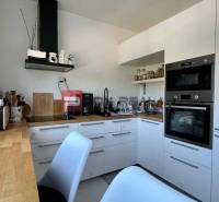 A kitchen in a 3-room apartment with white cabinets and a wooden countertop.
