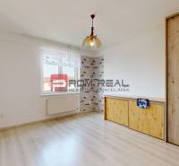 A room in a 4-room apartment with a wooden wardrobe and wallpaper on the wall.