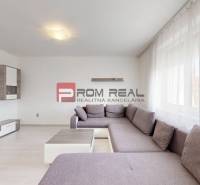 Living room in a 4-room apartment with a spacious sofa and television.