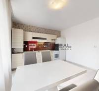 A bright kitchen in a 4-room apartment with a dining table and gray chairs.